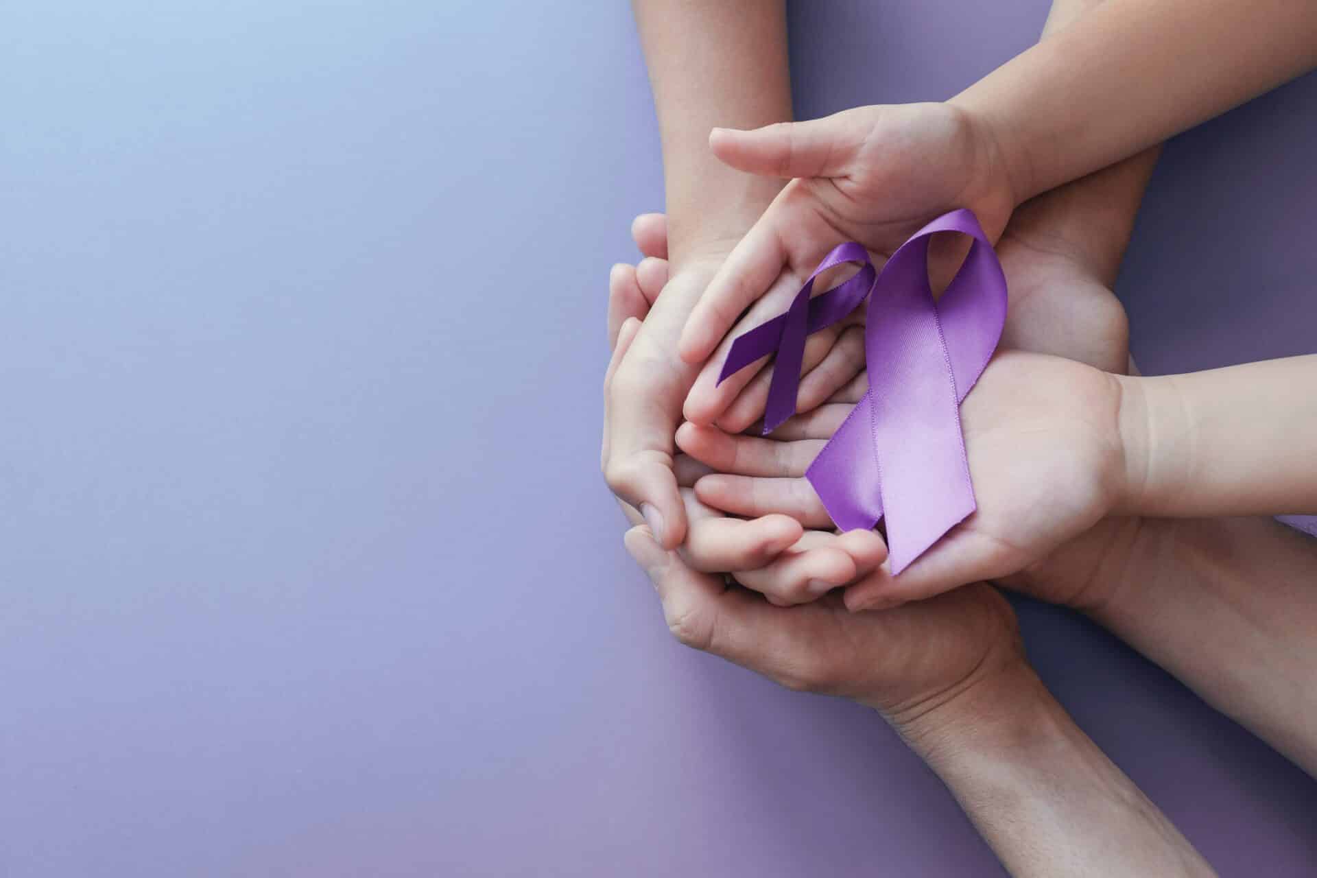 Adult and child hands holding purple ribbons, Alzheimer's disease, Pancreatic cancer, Epilepsy awareness, world cancer day on purple background