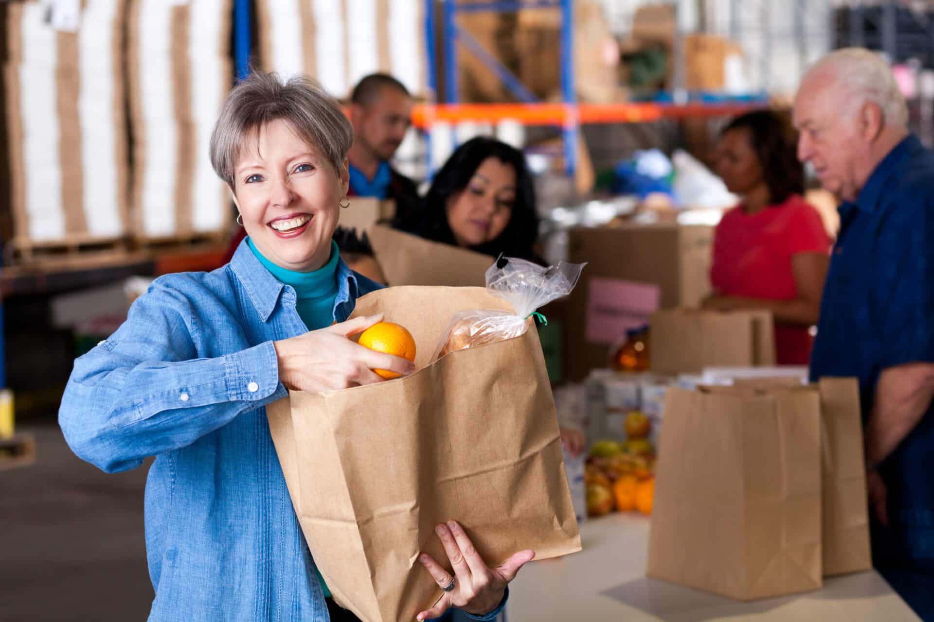 Woman with bag of groceries at a food pantry