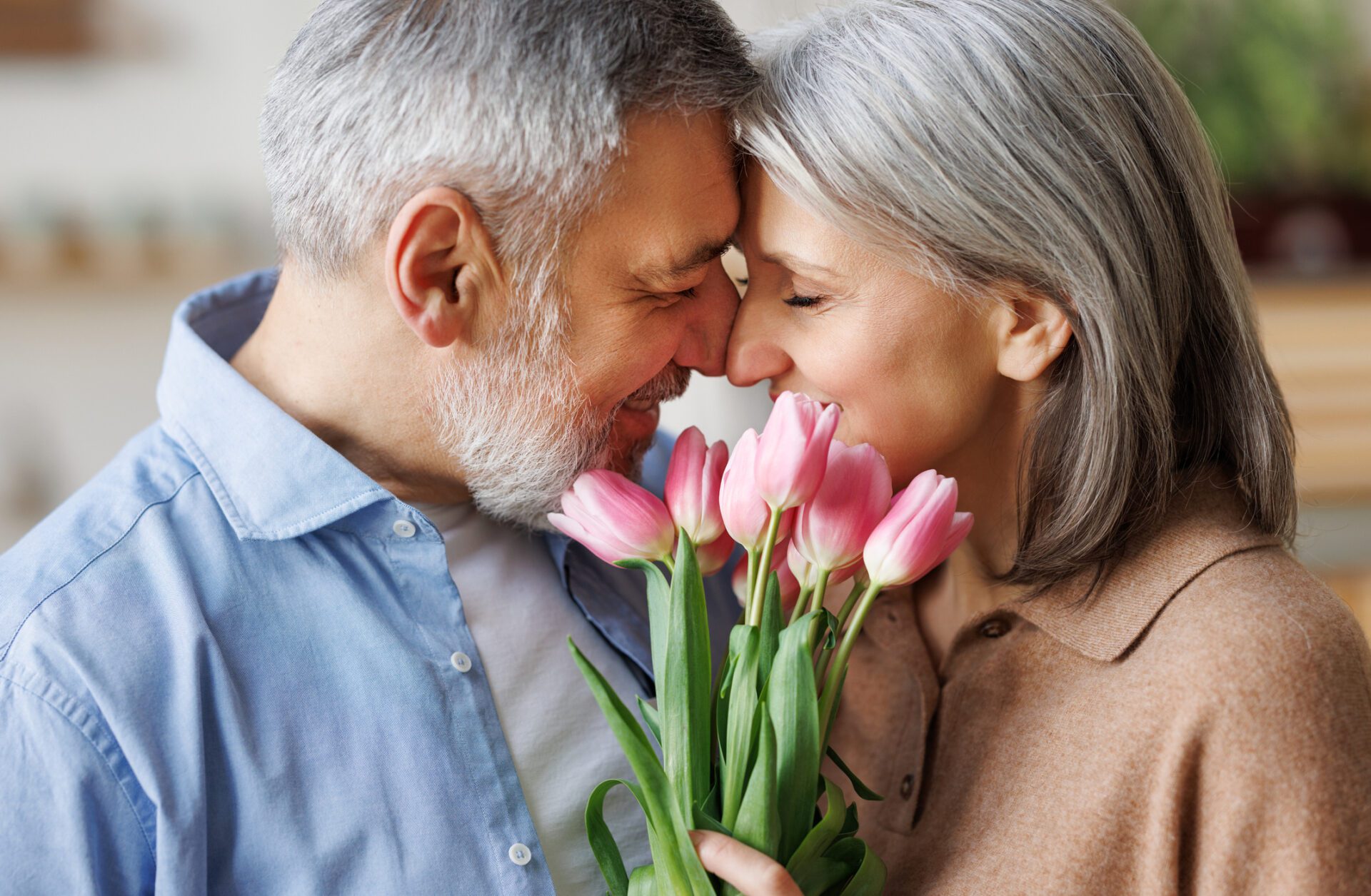 Couple in love hugging on Valentine's day. A loving husband gives his wife a bouquet of tulip